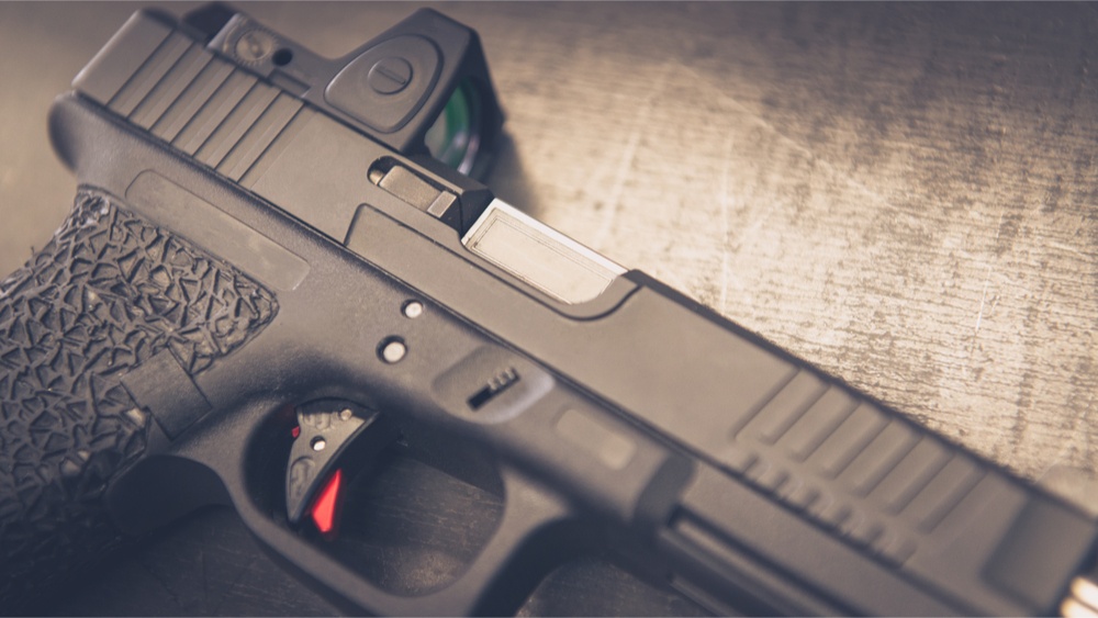 A pistol with a red dot sight.